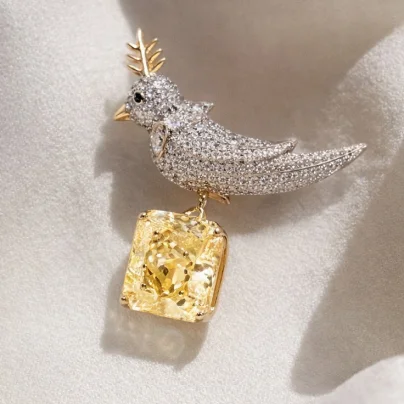Diamond bird brooch with yellow gemstone pendant detail