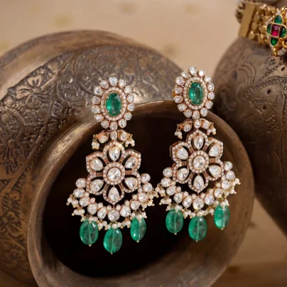 Close-up of emerald and polki chandelier earrings with pearl detailing