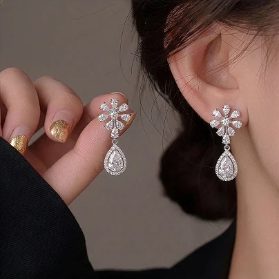 Close-up of floral diamond drop earrings with pear-shaped stones